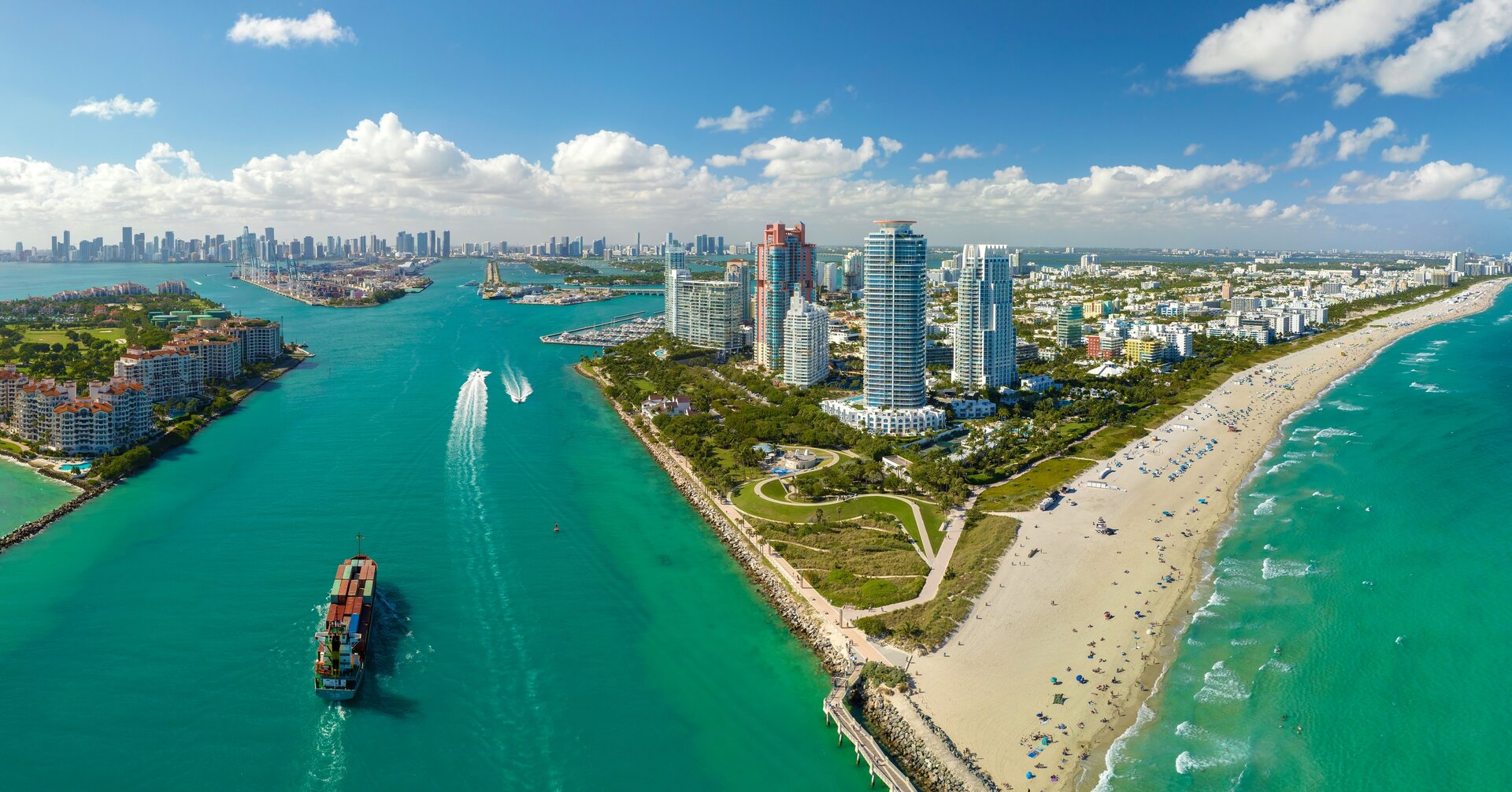 Aerial view of a beachside cityscape with a large body of water and a sandy beach.
